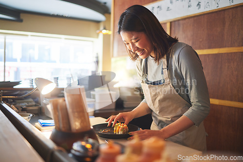 Image of Sushi, restaurant worker and woman with smile from food and Asian meal in a kitchen. Happy, female waiter or chef working with fish and rice for lunch order with cooking in Japanese bar with service