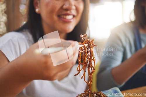 Image of Asian, noodles and woman at a restaurant eating for dinner or lunch meal using chopsticks and happy for ramen nutrition. Plate, young and person enjoy Japanese cuisine, food or diet at a table