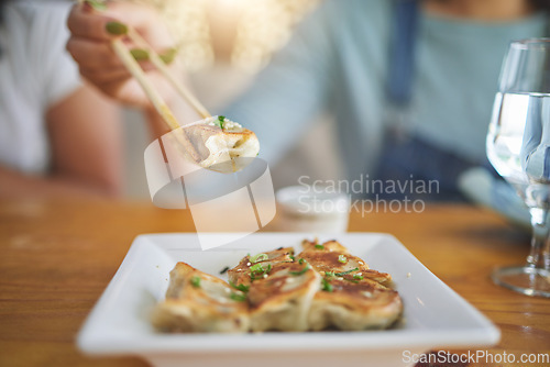 Image of Table, plate and chopsticks with a dumpling at a restaurant for food, Asian culture or fine dining. Health, hungry and a person with dinner, eating lunch or enjoying a fried dish or cuisine at a cafe