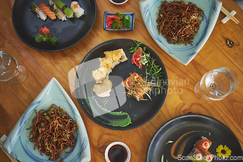 Image of Sushi restaurant, catering and plate in top view for service, lunch or dinner with noodles, chopsticks or fish. Japanese cuisine, table and food in diner, cafe or luxury for health, nutrition or diet