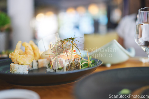 Image of Sushi restaurant, catering and seafood in closeup for service, brunch or dinner with wine, glass and fish meal. Japanese cuisine, menu and table in diner, cafe or luxury for health, nutrition or diet