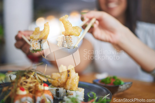 Image of Chopsticks, girl friends hands and shrimp sushi at a table with Japanese cuisine food at restaurant. Young women, eating and tempura prawn with fish for lunch and meal on a plate with a smile