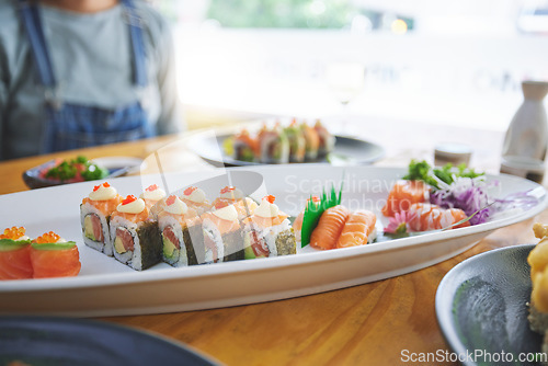 Image of Asian, sushi and luxury food at a restaurant for dinner or lunch meal at a healthy Japanese cafe on table. Plate, cuisine and fine dining takeaway or seafood from a Salmon menu for diet or nutrition