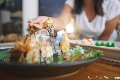 Image of Hand, closeup and chopsticks in sushi restaurant for diet, fine dining and party with catering platter. Person, healthy fish and salmon with culture, traditional or fast food in diner, bar or store