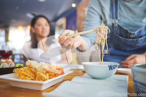 Image of Hand, ramen and chopsticks for Chinese food with a woman closeup in a restaurant to eat a meal. Soup, noodles and cuisine with a customer in an eatery for nutrition or traditional Japanese dinner