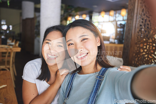 Image of Selfie, love and an LGBT couple in a restaurant for a romantic date together on their anniversary. Portrait, smile and a happy asian woman with her lesbian partner in a cafe for a celebration