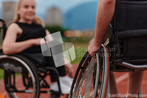 Image of A woman with disability in a wheelchair talking with friend after training on the marathon course