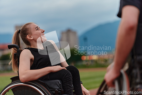 Image of A woman with disability in a wheelchair talking with friend after training on the marathon course