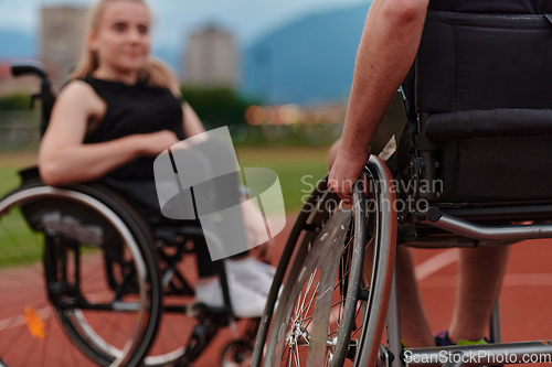 Image of A woman with disability in a wheelchair talking with friend after training on the marathon course