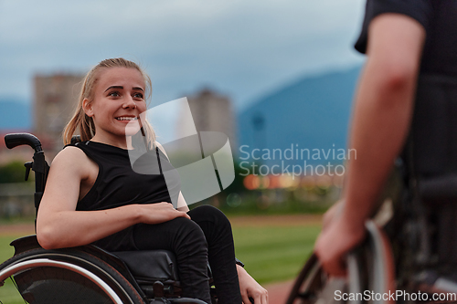 Image of A woman with disability in a wheelchair talking with friend after training on the marathon course