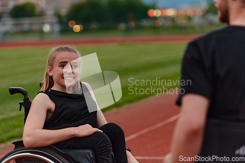 Image of A woman with disability in a wheelchair talking with friend after training on the marathon course