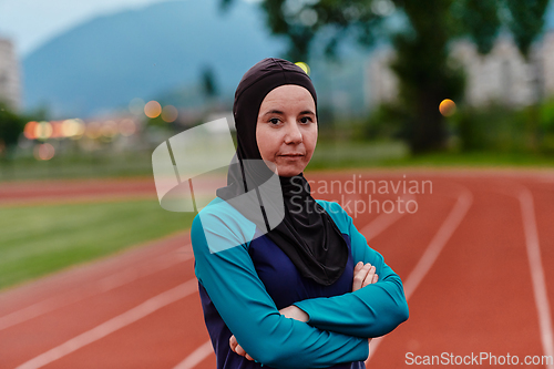 Image of A Muslim woman with a burqa, an Islamic sportswoman resting after a vigorous training session on the marathon course. A hijab woman is preparing for a marathon competition