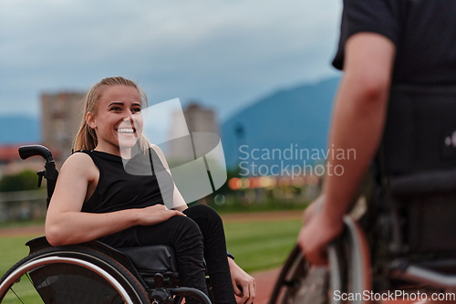 Image of A woman with disability in a wheelchair talking with friend after training on the marathon course