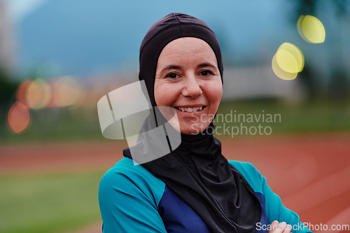 Image of A Muslim woman with a burqa, an Islamic sportswoman resting after a vigorous training session on the marathon course. A hijab woman is preparing for a marathon competition