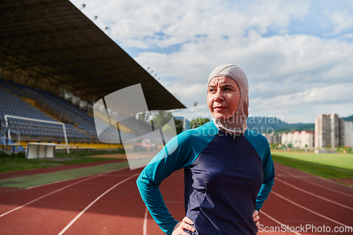 Image of A Muslim woman with a burqa, an Islamic sportswoman resting after a vigorous training session on the marathon course. A hijab woman is preparing for a marathon competition