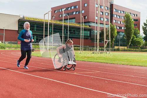 Image of A Muslim woman in a burqa running together with a woman in a wheelchair on the marathon course, preparing for future competitions.