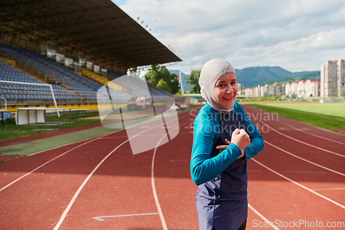 Image of A hijab woman in a burqa showing her boldness by showing her muscles on her arms