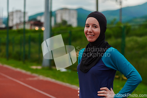 Image of A Muslim woman with a burqa, an Islamic sportswoman resting after a vigorous training session on the marathon course. A hijab woman is preparing for a marathon competition