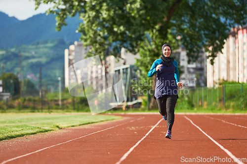 Image of A muslim woman in a burqa sports muslim clothes running on a marathon course and preparing for upcoming competitions