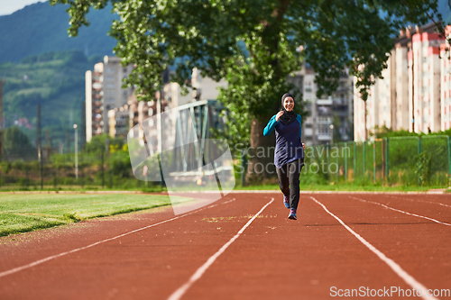 Image of A muslim woman in a burqa sports muslim clothes running on a marathon course and preparing for upcoming competitions