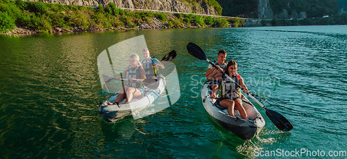 Image of A group of friends enjoying fun and kayaking exploring the calm river, surrounding forest and large natural river canyons during an idyllic sunset.