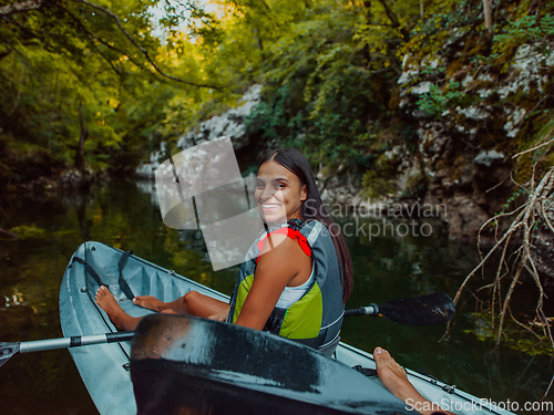 Image of A smiling woman enjoying a relaxing kayak ride with a friend while exploring river canyons