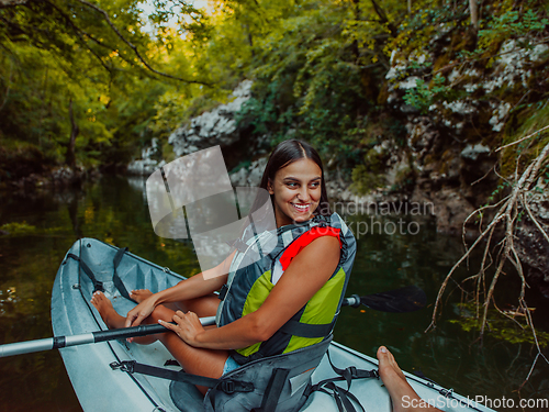 Image of A smiling woman enjoying a relaxing kayak ride with a friend while exploring river canyons