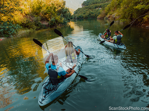 Image of A group of friends enjoying having fun and kayaking while exploring the calm river, surrounding forest and large natural river canyons