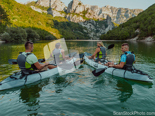 Image of A group of friends enjoying having fun and kayaking while exploring the calm river, surrounding forest and large natural river canyons