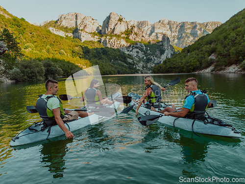 Image of A group of friends enjoying having fun and kayaking while exploring the calm river, surrounding forest and large natural river canyons