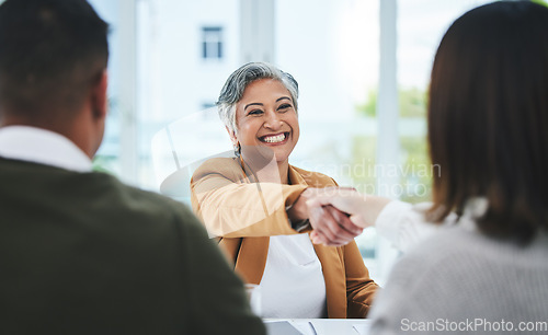 Image of Handshake, job interview or business people with a happy mature woman for partnership in office. We are hiring, smile or business people shaking hands for success, promotion or negotiation in meeting