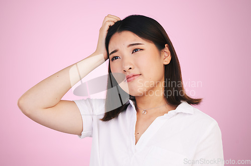 Image of Thinking, confused and question with an asian woman on a pink background in studio for problem solving. Face, doubt or why and a young person scratching her head with a mistake, error or fail