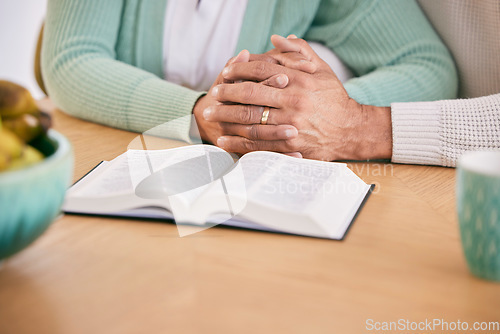 Image of Reading, bible and senior couple holding hands at home with book study and religion together. Prayer, support and elderly people with worship, learning and christian education with love and care