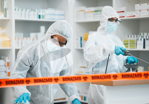 Image of Biohazard, chemical and cleaning with people in a pharmacy for decontamination after a medical accident. Hazmat, spray or disinfect with healthcare personnel in a drugstore to sanitize and isolate