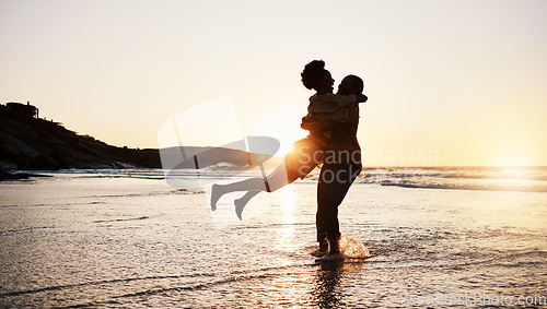 Image of Beach sunset, silhouette and couple hug, celebrate and enjoy romantic time together, bonding and relax in sea water. Wellness, summer freedom and dark shadow of people embrace on tropical anniversary
