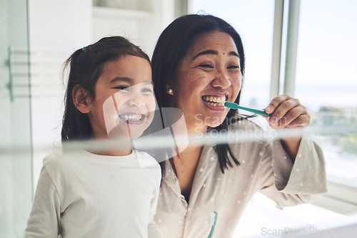 Image of Mother, happy kid or brushing teeth in dental hygiene, morning routine or healthcare by mirror in bathroom. Mom, smile or daughter cleaning mouth in tooth whitening, oral or gum care at home together