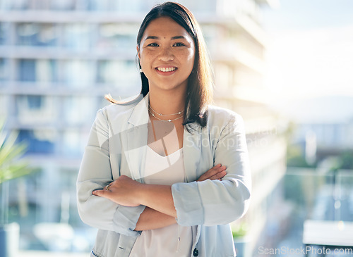 Image of Smile, crossed arms and portrait of a businesswoman in the office with confidence and happiness. Pride, career and face of a happy professional young Asian female lawyer standing in modern workplace.