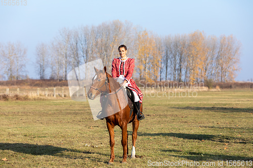 Image of Hungarian csikos horsewoman in traditional folk costume