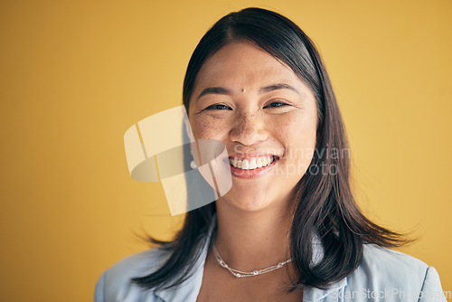 Image of Face, smile and Asian woman, designer and entrepreneur in studio isolated on a yellow background mockup space. Portrait, happy and creative professional, worker and startup employee in Cambodia.