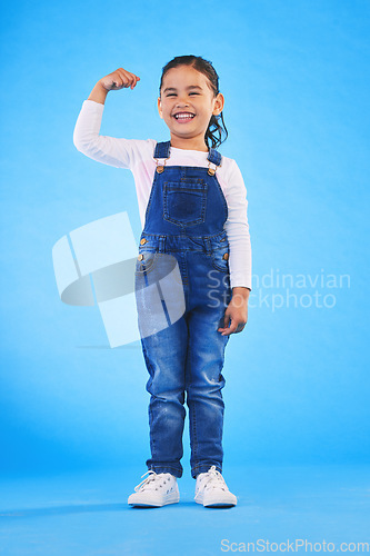 Image of Young, girl child and champion, winner and emoji with happiness, strong and excited isolated on blue background. Power, muscle and winning with success, body language and happy kid in a studio
