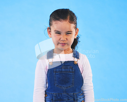 Image of Tantrum, attitude and portrait of child on blue background with upset, mad and frustrated facial expression. Behaviour, pout and young girl with sad face for anger, tantrum and emotion in studio