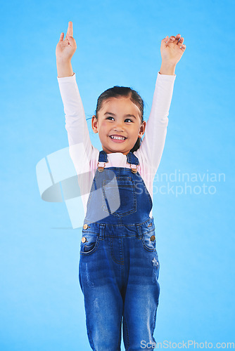 Image of Success, girl child and champion, winner and achievement with happiness and excited isolated on blue background. Cheers, yes and winning with celebration, pride and happy kid with arms up in a studio