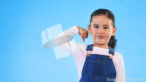 Image of Portrait, girl child and champion, winner and emoji with happiness, strong and excited isolated on blue background. Power, mockup space and winning with success, body language and happy kid in studio