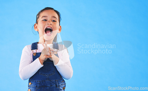 Image of Excited, youth and a child on a blue background with mockup for information. Playful, freedom and a young girl kid or model playing with happiness on a studio background with space for creativity