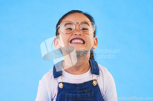 Image of Glasses, student smile and Asian child in portrait in studio isolated on a blue background mockup space. Happy, nerd and face of school kid, girl or geek in casual clothes, fashion and style in Japan