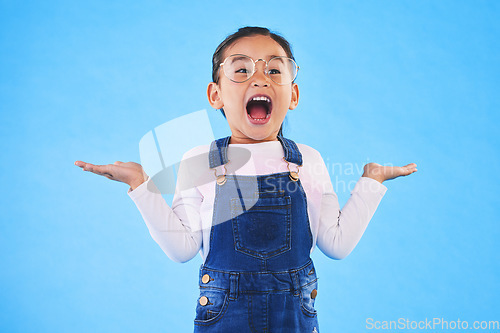 Image of Excited, happy surprise and girl kid with hand gesture, expression and announcement isolated on blue background. Wow, reaction and happiness, news and opportunity with drama and open mouth in studio