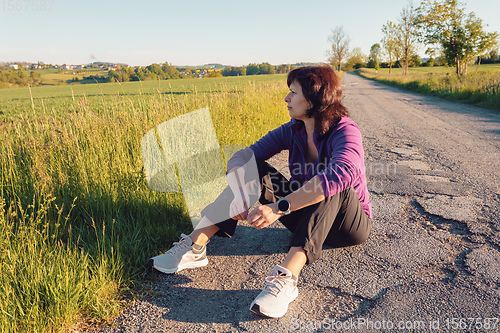 Image of happy european woman resting on road