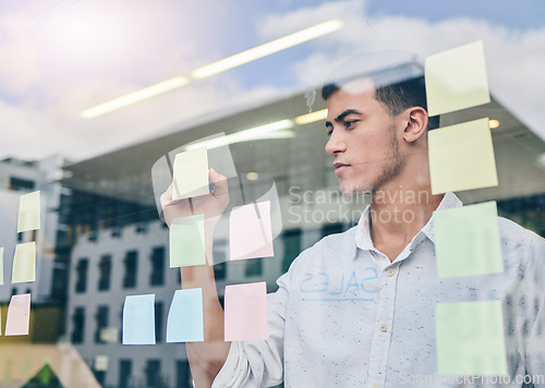 Image of Glass, window and man, brainstorming and writing on sticky note, project management and strategy in workplace. Ideas, planning and business with moodboard, calendar and goals with productivity