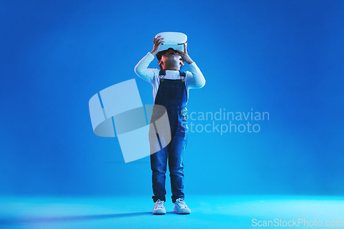 Image of Glasses, virtual reality and metaverse with girl, online games or digital transformation on blue studio background. Kid, child and model with vr headset with technology, futuristic and live streaming