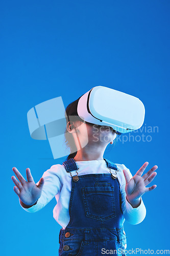 Image of Metaverse, girl and child virtual reality glasses, innovation and future on a blue studio background. Kid, vr headset or technology for online gaming, futuristic and augmented reality with connection